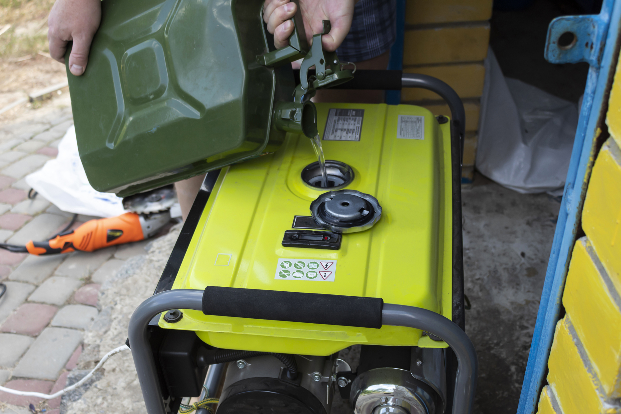 a person pouring liquid into a gasoline generator